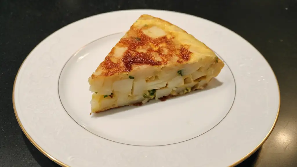 Una cuña de tortilla de patatas con cebolla y perejil