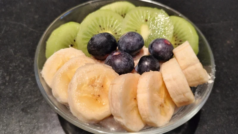 Porridge de avena cocida con con plátano, kiwi y arándanos.