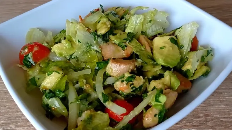 Un cuenco con ensalada fresca de pollo, aguacate y cítricos.